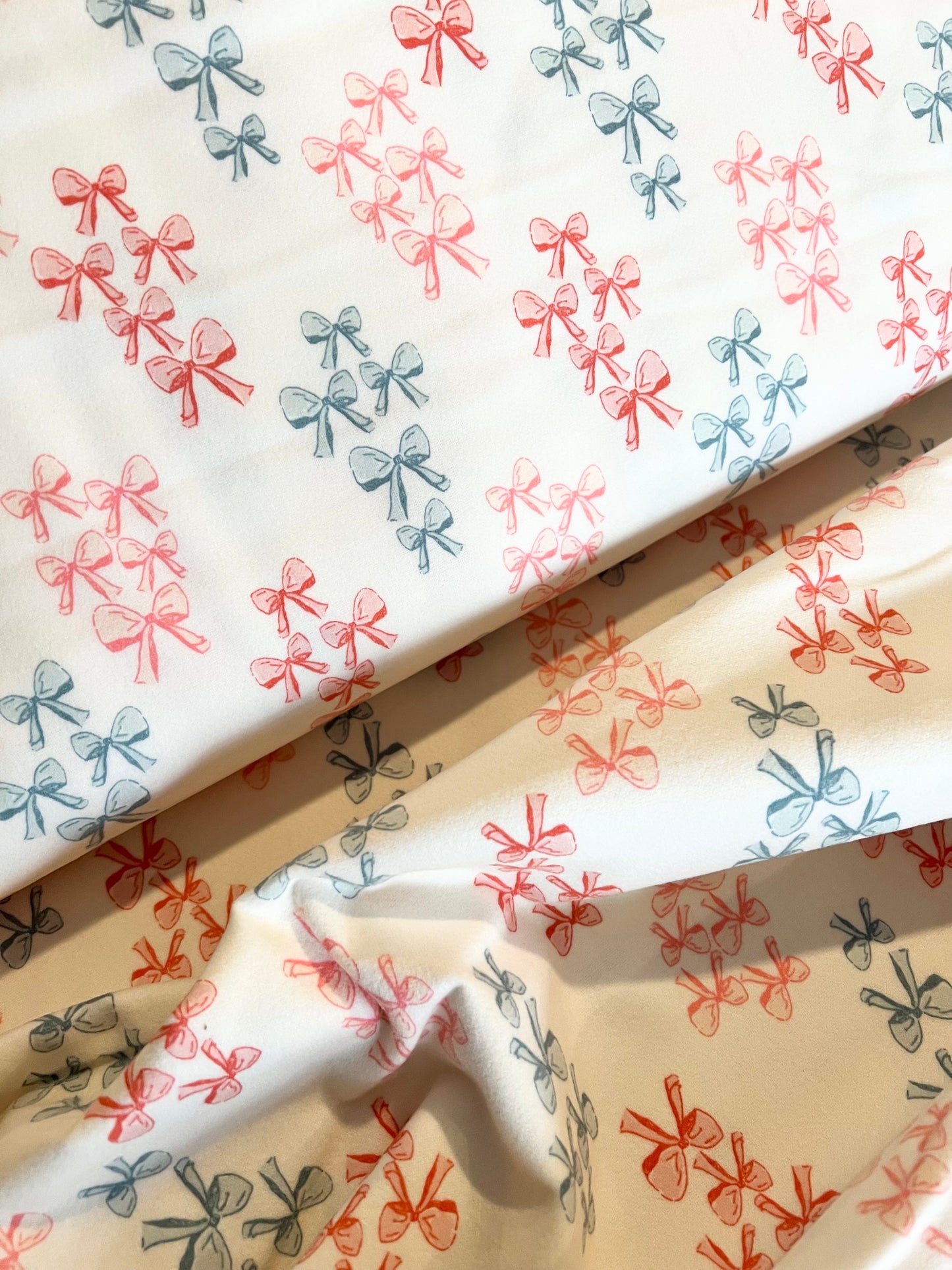 Fabric with pink and blue bow pattern on a white background