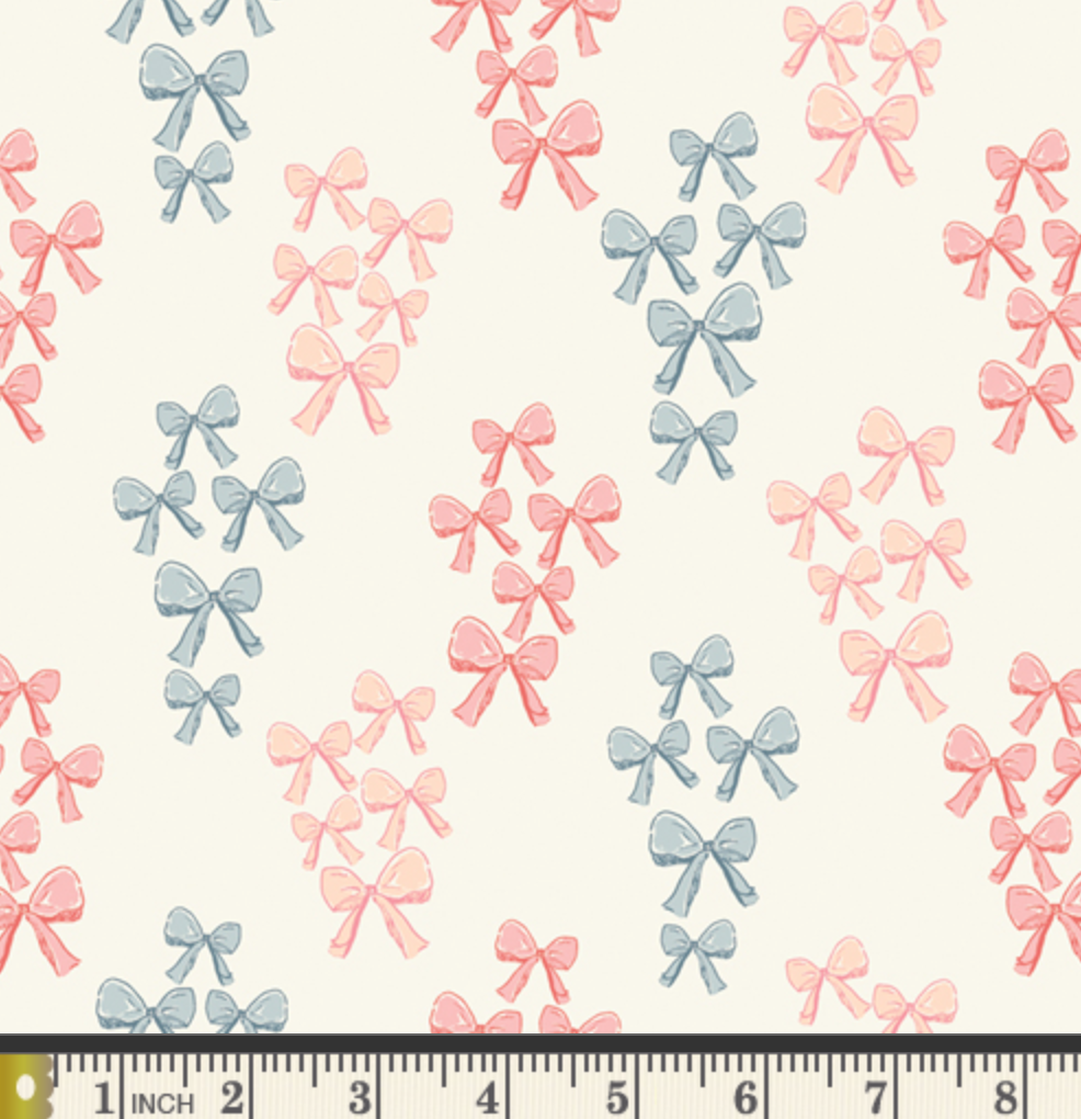 Pattern of pink and blue bows on a white background with a ruler at the bottom.