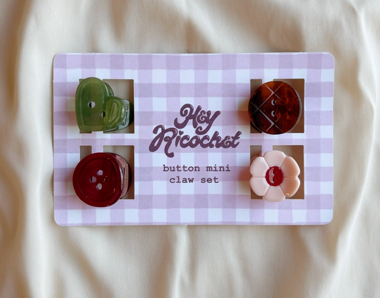 Set of 4 mini Button Hair claws: round merlot red, round mahogany brown with carved lines, heart-shaped fir green, and flower-shaped cream with merlot red center.